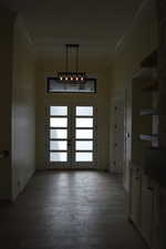 Entrance foyer with french doors, ornamental molding, and light wood-style floors