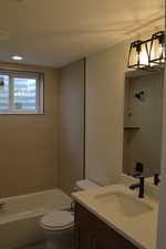 Full bathroom with vanity, shower / bathtub combination, and a textured ceiling