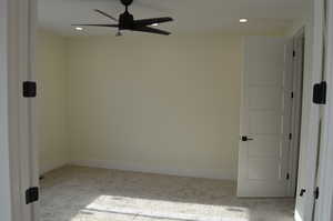 Spare room featuring light colored carpet, a ceiling fan, and recessed lighting