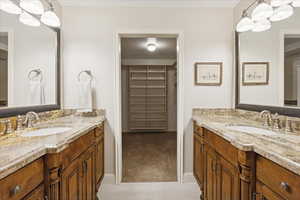 Primary bathroom featuring large walk-in closet and dual vanities.  Closet is carpeted and tile floor in front of vanities is heated.