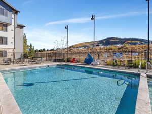 Community pool featuring a mountain view and a patio