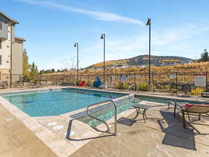 Community pool featuring a patio and a mountain view