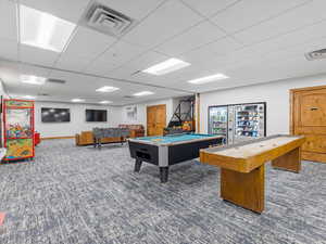 Recreation room with a paneled ceiling and billiards table