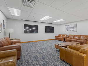 Living room with a paneled ceiling and baseboards
