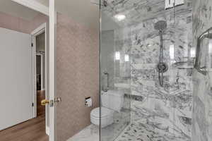 Bathroom with a shower stall and toilet