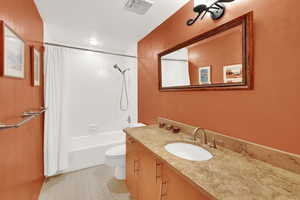 Bathroom with shower / bath combo with shower curtain, light tile patterned flooring, and vanity