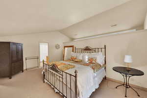 Bedroom featuring carpet and lofted ceiling