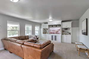 Living room featuring light colored carpet and baseboards