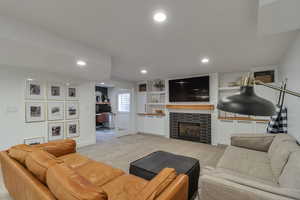 Living area with a desk, light colored carpet, a fireplace, and recessed lighting