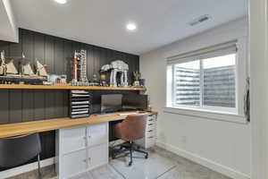 Home office with recessed lighting, light colored carpet, and built in desk