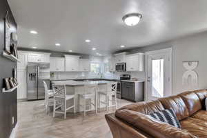 Living room with light wood-style flooring and recessed lighting