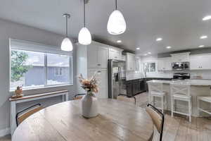 Dining space with light wood-type flooring and recessed lighting