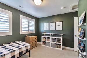Bedroom with light carpet and attic access