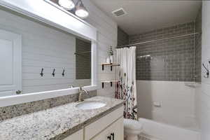 Full bath featuring shower / tub combo and vanity