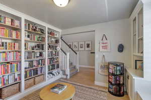 Sitting room featuring light wood-type flooring and stairs