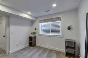 Unfurnished bedroom with light carpet and recessed lighting