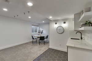 Dining area with dark tile patterned floors, a textured ceiling, recessed lighting, and dark colored carpet