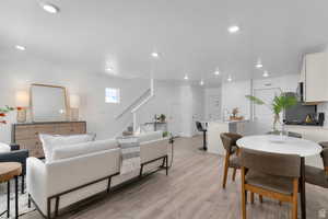 Living area with stairs, light wood-style floors, a textured ceiling, and recessed lighting