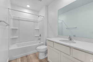Bathroom featuring tub / shower combination, light wood-style flooring, and vanity