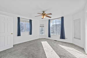 Spare room featuring light colored carpet and a ceiling fan