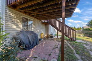 View of patio featuring stairs, grilling area, and a deck