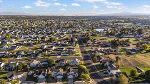 Aerial view of property and surrounding area with nearby suburban area and mountains