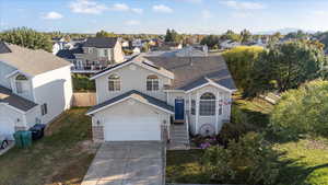 View of front of house with driveway, a garage, a front lawn, a shingled roof, and a residential view