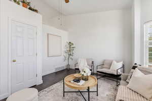 Living room with dark wood finished floors, a ceiling fan, and lofted ceiling