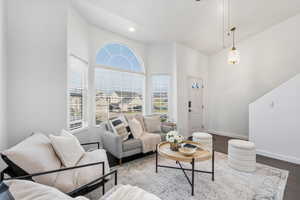 Living room with dark wood finished floors, a ceiling fan, and lofted ceiling