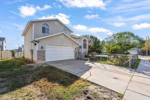 View of front of home with concrete driveway and a garage
