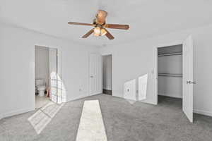 Unfurnished bedroom with carpet, ceiling fan, and ensuite bathroom