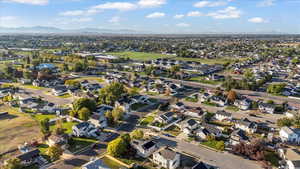 Aerial view of property and surrounding area featuring nearby suburban area and mountains