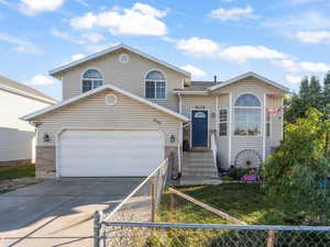 View of front facade featuring concrete driveway, brick siding, and a garage