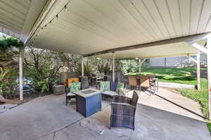 View of patio featuring outdoor dining area, a fire pit, and area for grilling