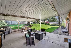 View of patio with an outdoor fire pit and outdoor dining area