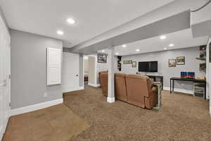 Living area with light carpet, recessed lighting, and light tile patterned flooring
