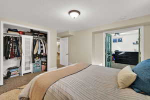 Carpeted bedroom with a textured ceiling and a closet