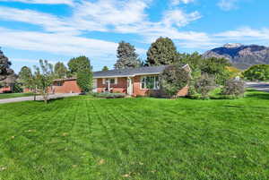 Ranch-style home featuring a front yard and brick siding