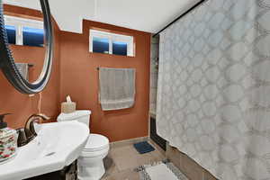 Bathroom featuring curtained shower, light tile patterned floors, and vanity