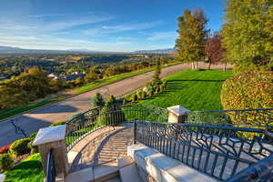 Surrounding community featuring a patio area, a mountain view, and a yard