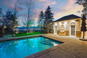 View of swimming pool with a patio, an outdoor structure, and a storage structure