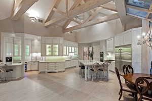 Dining room featuring high vaulted ceiling, beamed ceiling, and a chandelier