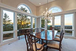 Dining room with light carpet, a chandelier, and recessed lighting