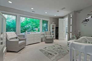 Bedroom with carpet floors, recessed lighting, and a nursery area