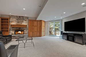 Living room featuring light colored carpet, a fireplace, and recessed lighting