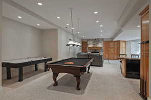 Recreation room featuring light carpet, recessed lighting, a stone fireplace, and pool table