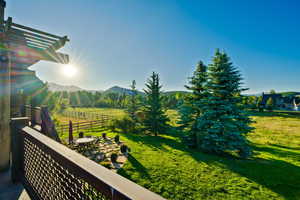 View of yard featuring a patio, a mountain view, outdoor dining area, and a view of rural / pastoral area