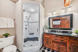 Bathroom with a shower stall, vanity, and tile patterned flooring