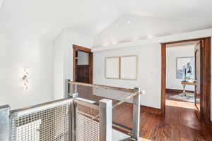 Corridor featuring vaulted ceiling and dark wood finished floors