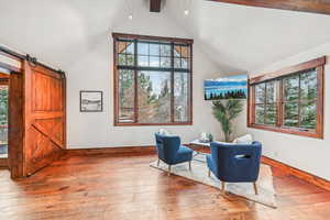 Living area featuring light wood-style floors, healthy amount of natural light, and a barn door